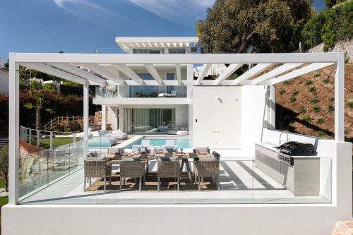 a patio with a table and chairs and a swimming pool at Villa Alma in Marbella
