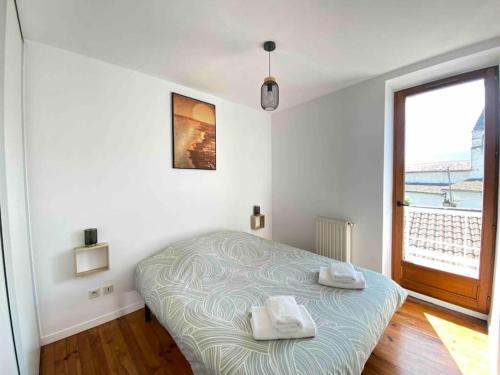 a bedroom with a bed with two towels on it at Le vieux Moyrenc in Moirans