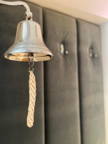 a bell hanging from a wall next to some cabinets at Seaside Park apartamenty prywatne z widokiem na morze in Kołobrzeg