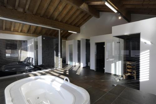 a large bathroom with a bath tub in a room at Apartments Residenz Iris in Leukerbad