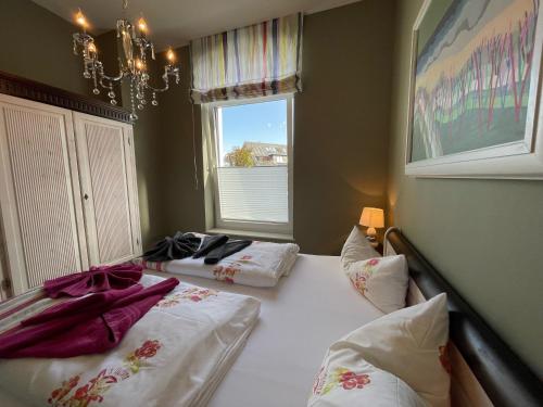 2 camas individuales en una habitación con ventana en Apartment Wilhelmine en Borkum