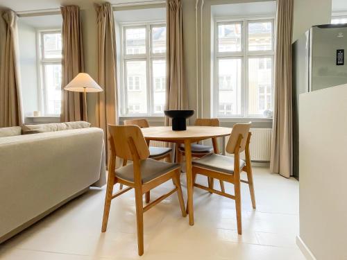 a living room with a table and chairs and a couch at Beautiful One-Bedroom Apartment in CPH City in Copenhagen