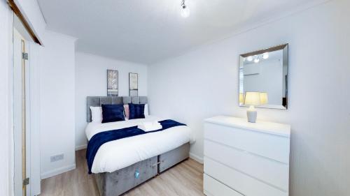 Dormitorio con cama con espejo y tocador en Stunning Ranworth House Sleeps 5, en Bedford