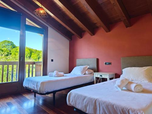 two beds in a room with a balcony at Els Tres Sols in Camprodon