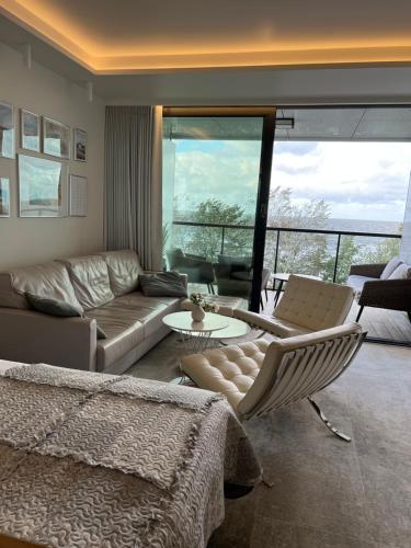 a living room with a couch and a table at Seaside Park apartamenty prywatne z widokiem na morze in Kołobrzeg