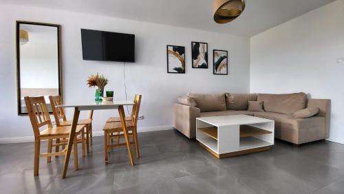 a living room with a couch and a table at Apartamenty Czerwona Stodoła in Kłodzko