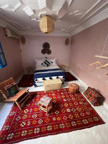 a bedroom with a bed and a red rug on the floor at Riad Fz Marrakech in Marrakech