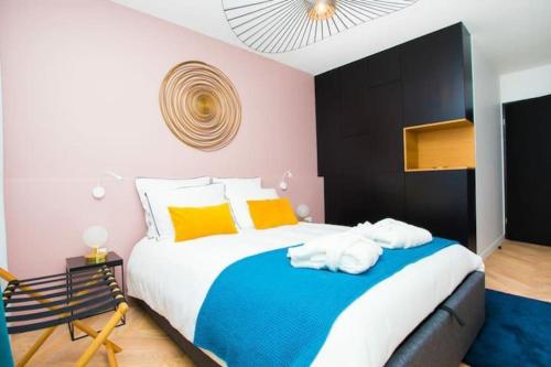 um quarto com uma cama grande e almofadas coloridas em Art déco appartement Disneyland em Chessy