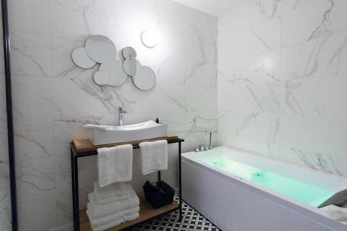 uma casa de banho com uma banheira e um lavatório e uma banheira em Art déco appartement Disneyland em Chessy
