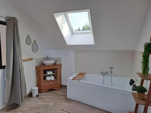 un bagno con vasca e lavandino di Gîte du Plantagenêt - Piscine intérieure privative a Rouez