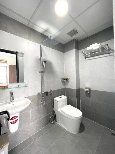 a bathroom with a toilet and a sink at BIG Hotel Huế in Hue