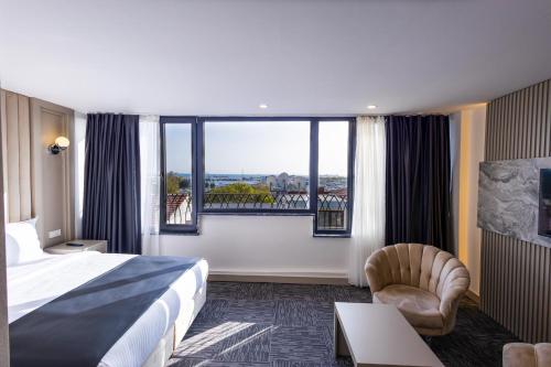 um quarto de hotel com uma cama e uma grande janela em Moss Hotel YENİKAPI em Istambul