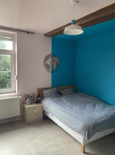 a blue bedroom with a bed and a window at La Ferme in Ascq