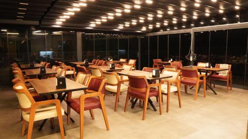 ein Restaurant mit Holztischen, Stühlen und Lampen in der Unterkunft Amber Palace Hotel in Istanbul