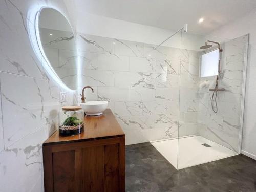ein Bad mit einem Waschbecken und einer Dusche mit einem Spiegel in der Unterkunft Well’Home Bali - Superbe villa au Nord de Toulouse in Mirepoix-sur-Tarn