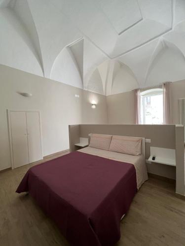 - une chambre blanche avec un grand lit dans l'établissement Il Soprano, à Altamura