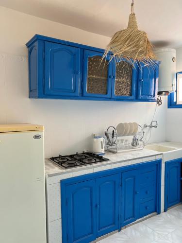 a blue kitchen with a stove and blue cabinets at Riad Fz Marrakech in Marrakech