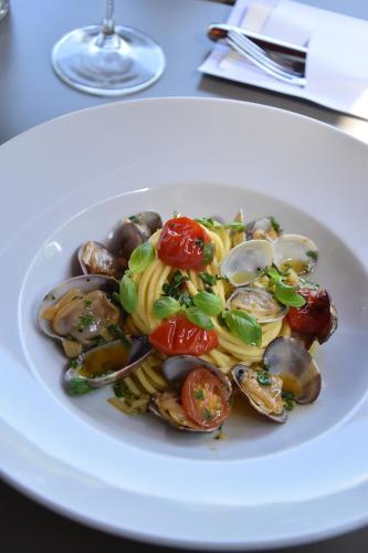 a plate of food with mussels and pasta on a table at Spa & Resort Bachmair Weissach, LUXURY FAMILY RESORT in Rottach-Egern