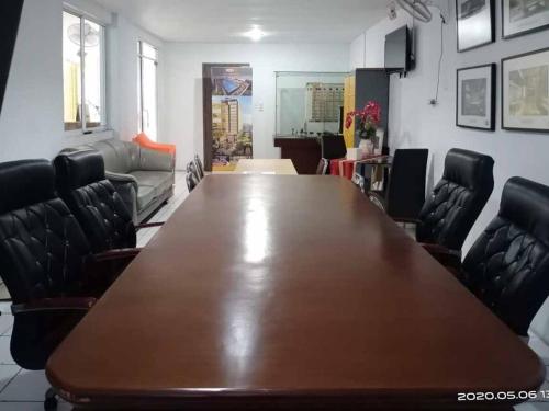 a conference room with a large wooden table and chairs at RedDoorz At Jalan Japaris Medan in Medan