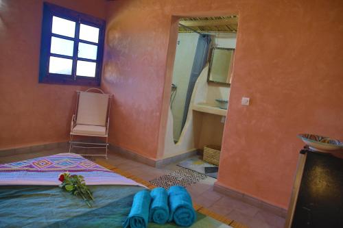 a bedroom with a bed with blue shoes on the floor at Dar Koujane in Marrakesh