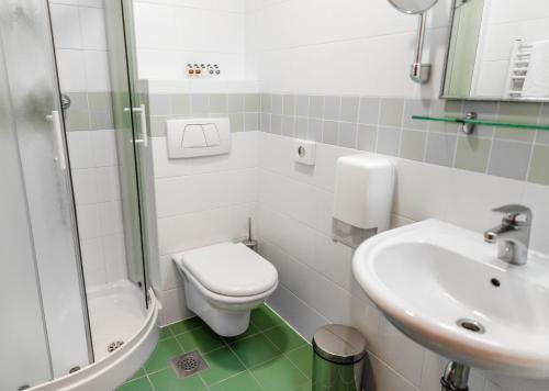 a bathroom with a toilet and a sink and a shower at Hotel Kranjska Gora in Kranjska Gora