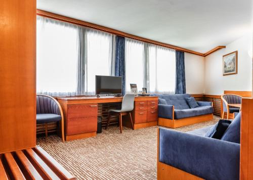 an office with a desk with a computer and chairs at Hotel Kranjska Gora in Kranjska Gora
