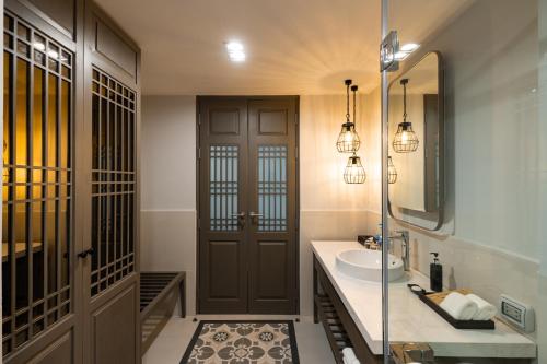 a bathroom with a sink and a mirror at Bella Nara Phuket Naiyang Beach in Nai Yang Beach
