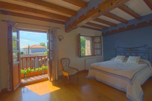 una camera con letto e balcone di La Casa del Bosco a Suances