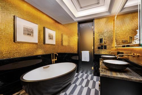 a bathroom with a large tub and two sinks at THE KARL LAGERFELD in Macau