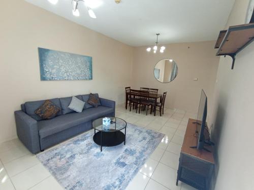 een woonkamer met een bank en een tafel bij Marbella Holiday Homes - Al Nahda 2BHK in Dubai