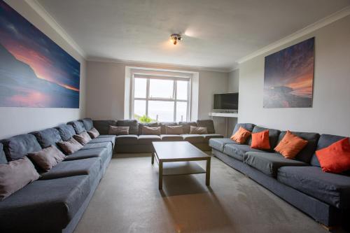 a living room with a large couch and a table at OA Surf Club in Bude