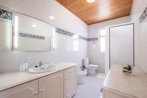 a white bathroom with a sink and a toilet at Villa Heredia by GALMI in Ribeira Brava