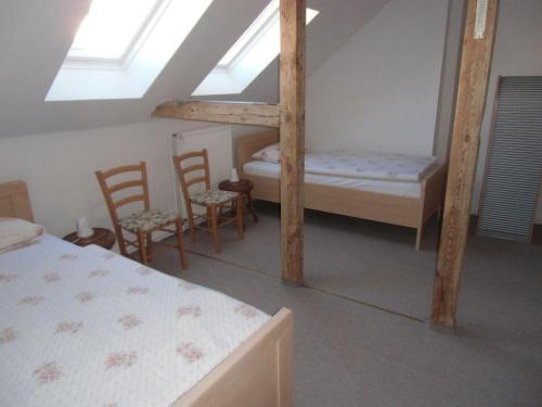 a bedroom with two bunk beds and two chairs at Ferienwohnung-Bille in Luckenwalde