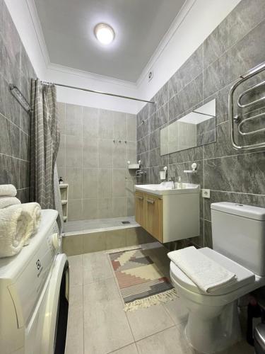 een badkamer met een toilet en een wastafel bij Уютная студия с видом на Ботанический парк in Astana