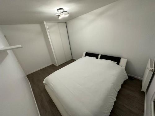 1 dormitorio con 1 cama blanca en una habitación en Appartement neuf, tout équipé ! en Eaubonne