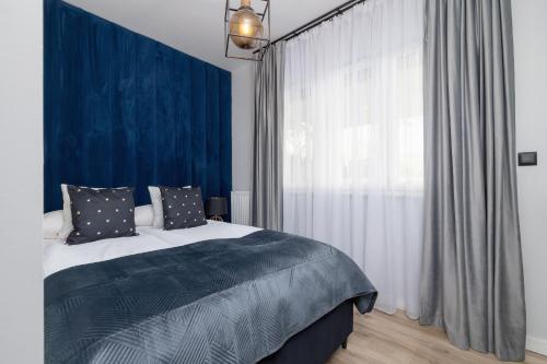 a bedroom with a bed and a large window at Lux Kraków Apartment with Parking & AC just 1,5 km from Main Square by Renters Prestige in Krakow