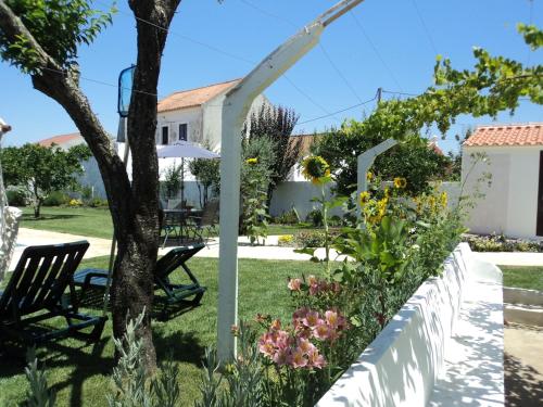 a garden with a white fence and flowers at Casas da Moagem in São Domingos