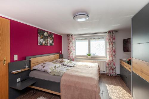 een slaapkamer met een bed en een paarse muur bij Fewo Schuch in Pirna