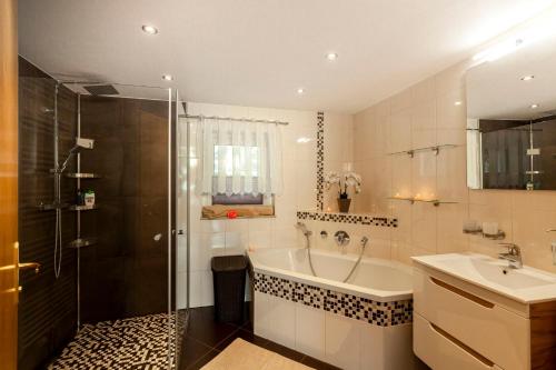 een badkamer met een bad, een wastafel en een douche bij Fewo Schuch in Pirna