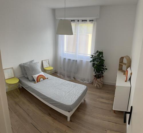 een slaapkamer met een bed en een raam bij Superbe F4 hyper centre/ parc pasteur in Orléans