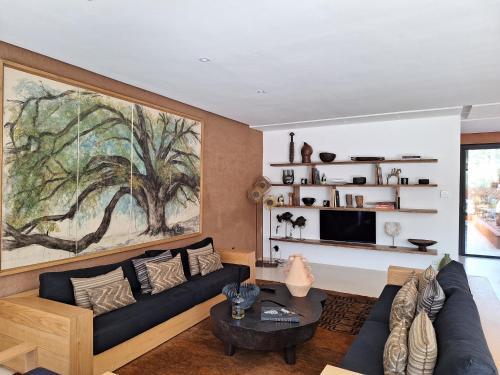 a living room with a large painting on the wall at Villa Madjha Ecolodge Marrakech in Marrakech