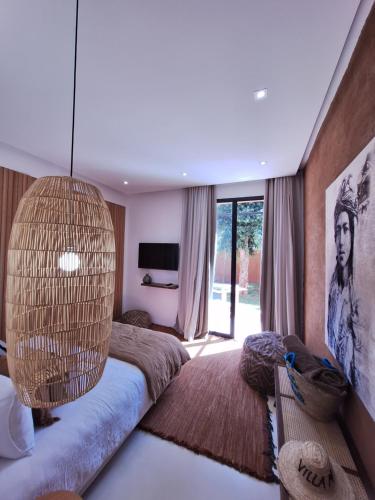 a living room with a couch and a chandelier at Villa Madjha Ecolodge Marrakech in Marrakech