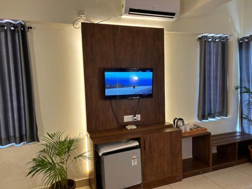 a living room with a flat screen tv on a wall at The Ocean Park Beach Resort in Kovalam