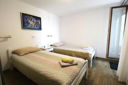 Una habitación de hotel con dos camas y una ventana. en Apartment Karmen with sea view, en Crveni Vrh