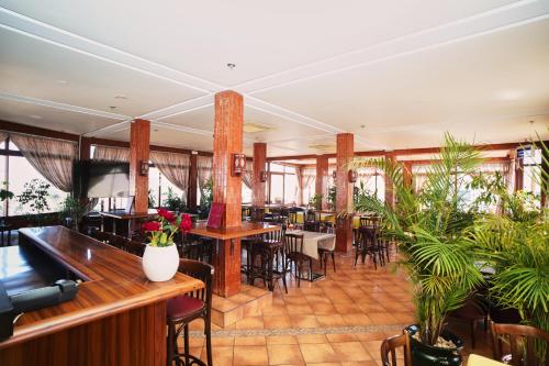 um restaurante com mesas, cadeiras e plantas em Hôtel Texuda em Rabat
