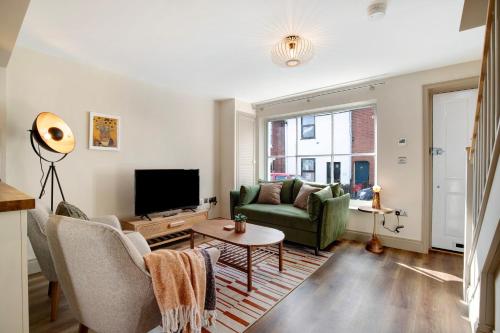 a living room with a couch and a tv at Beautifully refurbished cottage in lower Wivenhoe. in Wivenhoe