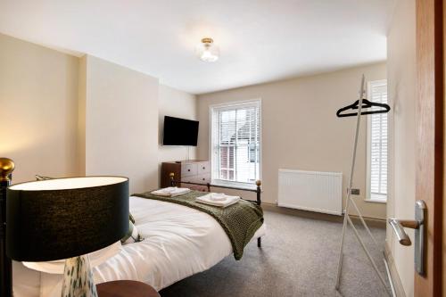 a bedroom with a bed and a lamp in it at Beautifully refurbished cottage in lower Wivenhoe. in Wivenhoe