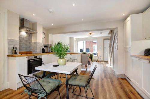 een keuken en een woonkamer met een tafel en stoelen bij Beautifully refurbished cottage in lower Wivenhoe. in Wivenhoe