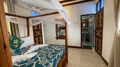 a bedroom with a bed with a blue and white comforter at Aquarium Beach House in Nungwi