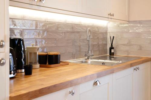 a kitchen with a sink and a counter top at Beautifully refurbished cottage in lower Wivenhoe. in Wivenhoe